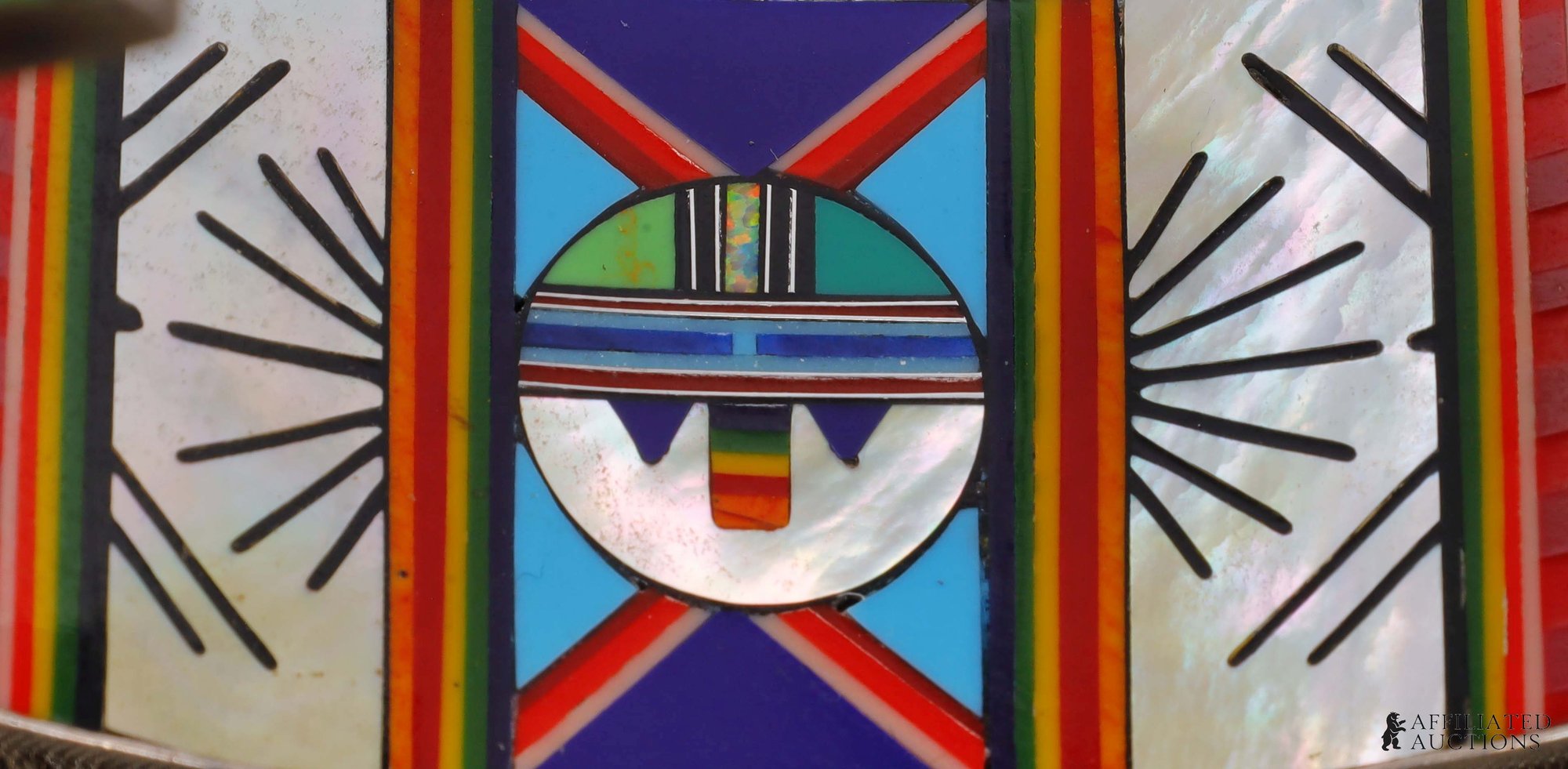 Close-up of the inlaid sun face and mother of pearl rays inside the cuff