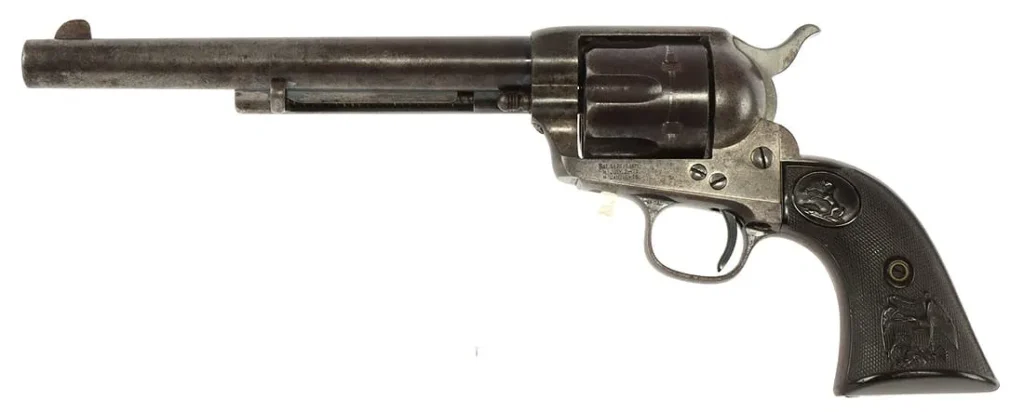 A vintage revolver with a grey metallic finish and wooden grip, featuring a six-chamber cylinder and a long barrel.