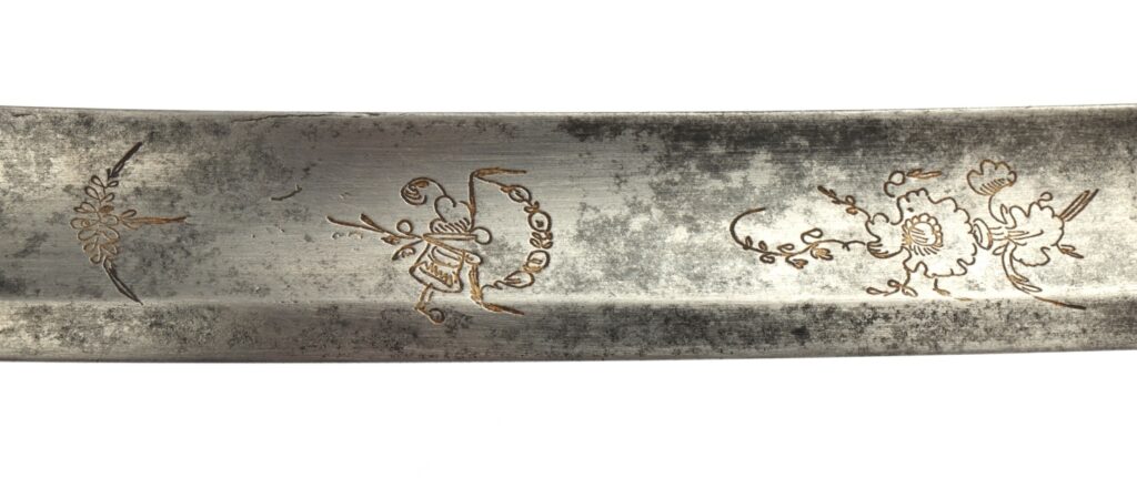 Close-up of an ornate silver plate, featuring intricate floral engravings and a vintage patina.