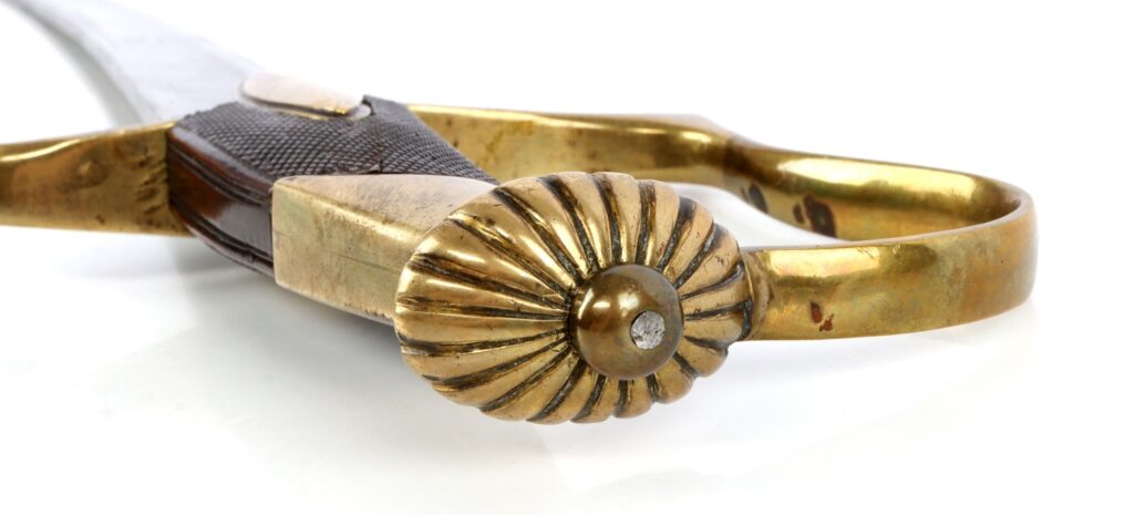 Close-up of a vintage pair of brass scissors with a decorative handle design.