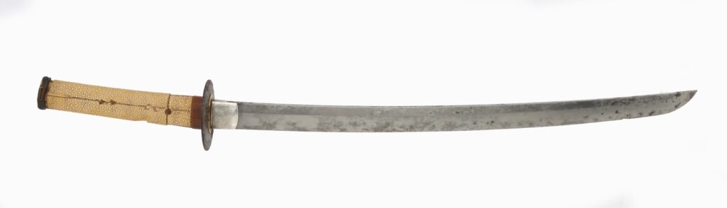 A traditional curved sword with a textured handle and a circular guard, displayed against a white background.