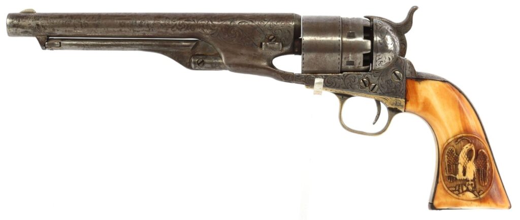 A vintage revolver with intricate engravings and a carved handle featuring a decorative scene.